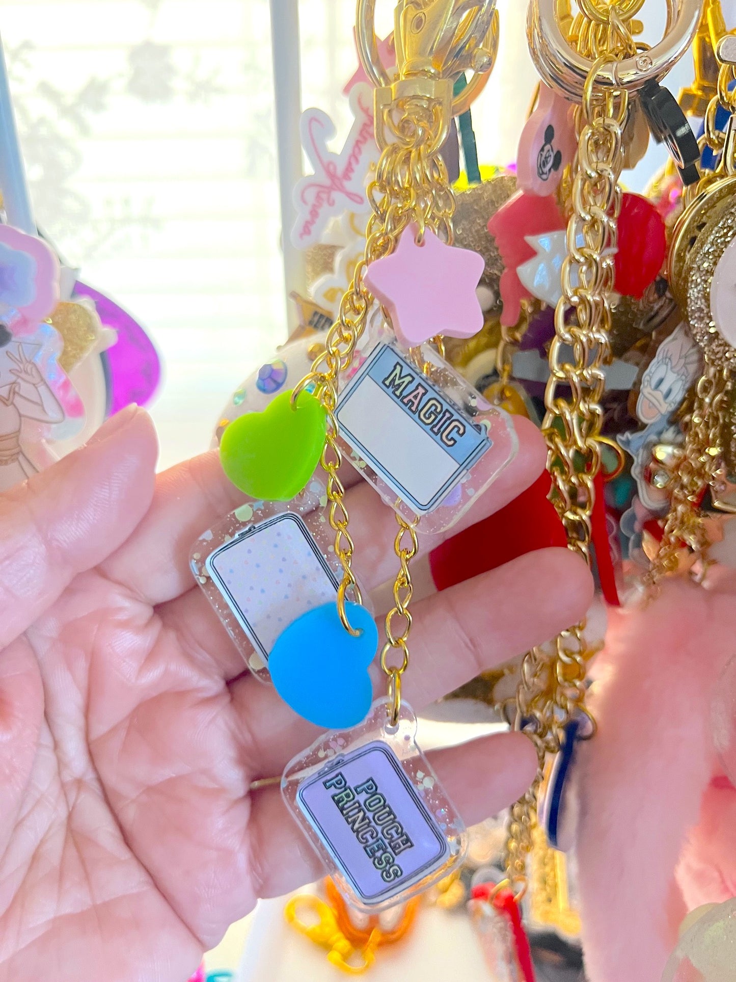 Colorful keychain with various charms held in a hand against a blurred background