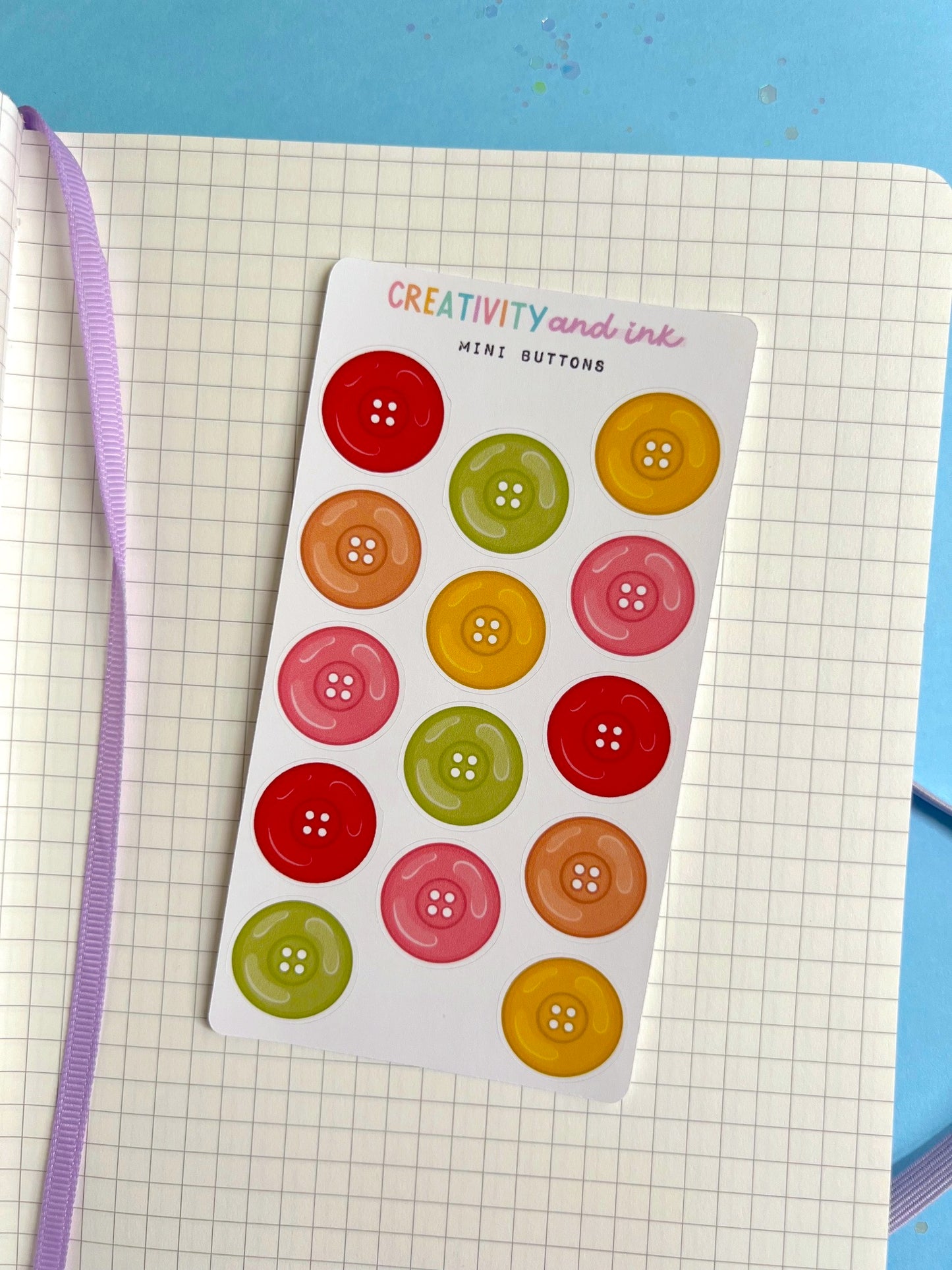 Sheet of colorful button stickers on a grid surface