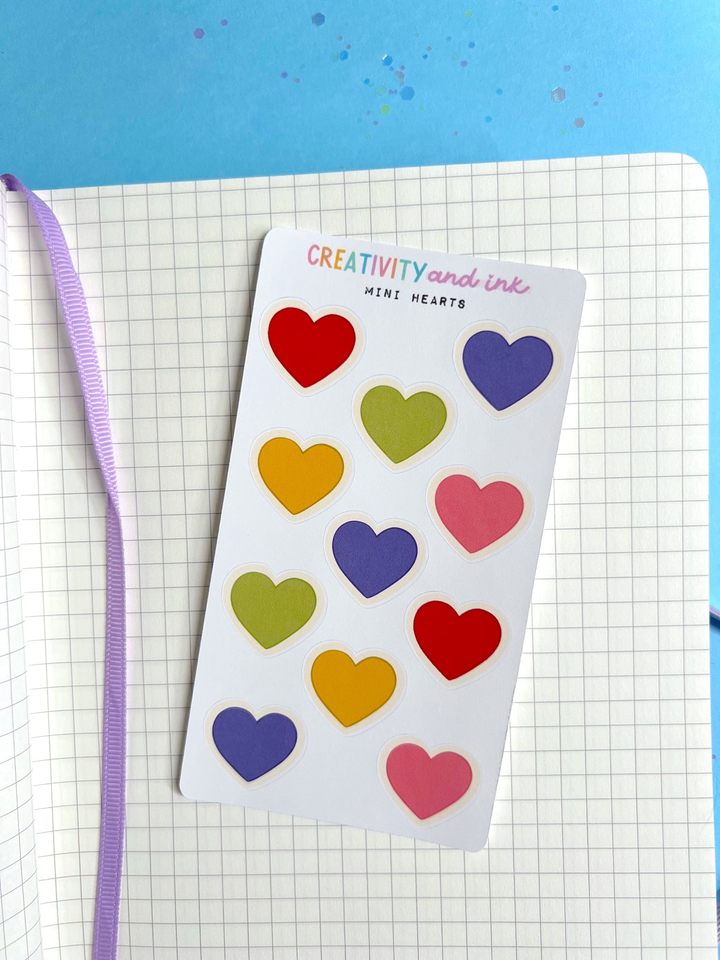 mini hearts as a sticker sheet on top of a notebook background
