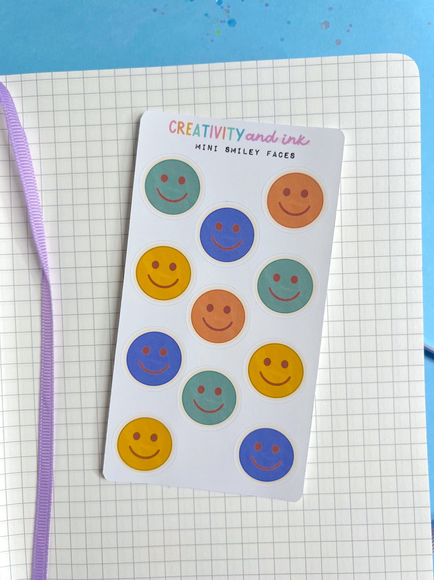 mini smiley faces as a sticker sheet on a notebook background