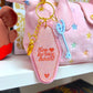 Pink keychain with 'Key to my heart' text and key charm on a pink bag.