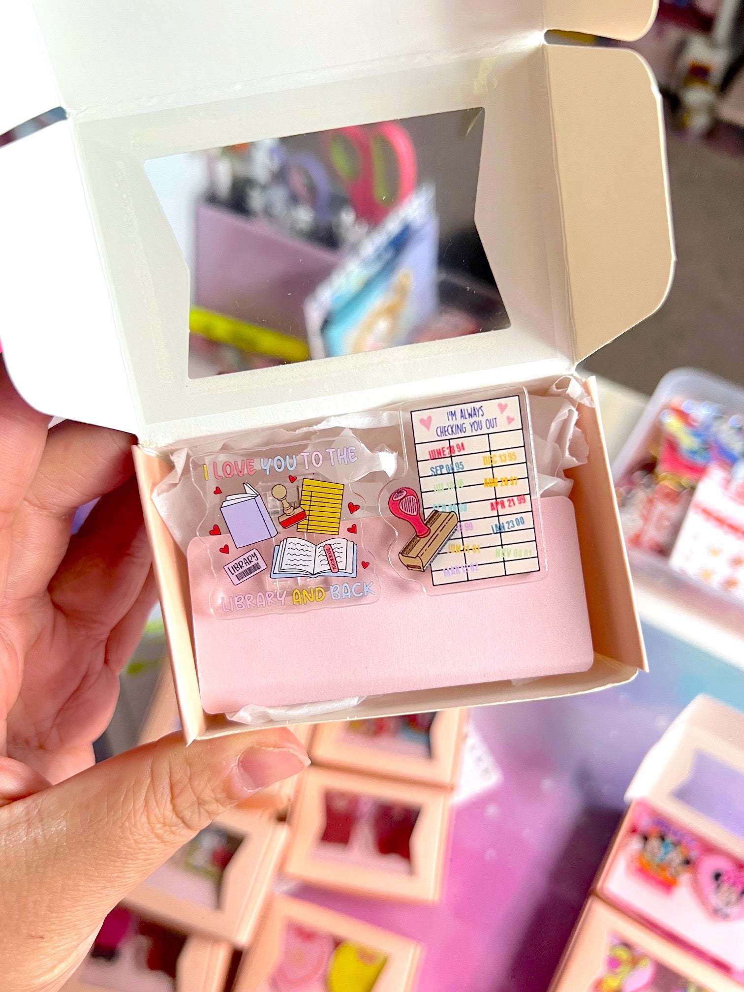 Hand holding a small box with decorative pins and cards.