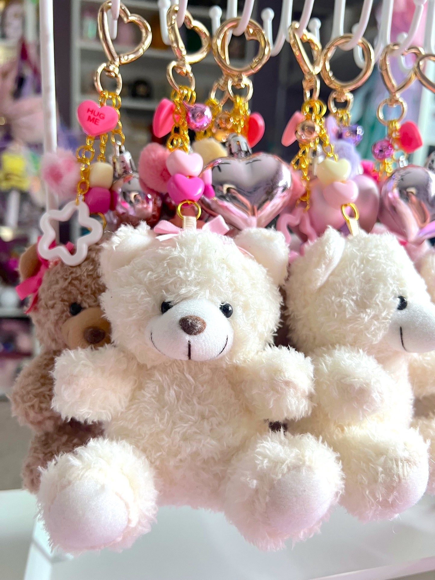 Plush teddy bear keychain with decorative elements on a white surface