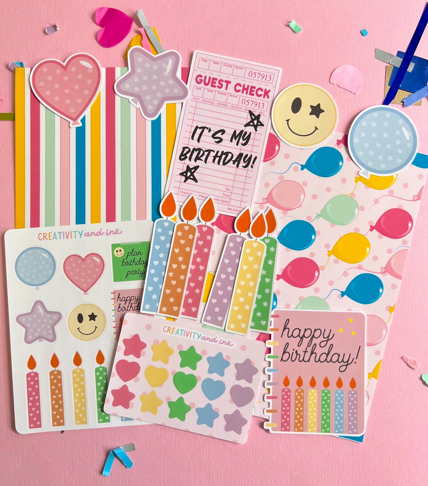 Collection of birthday-themed stationery items on a pink background