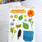 a mix of items including flowers buttons and more as a sticker sheet on top of a notebook background 