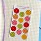 Sheet of colorful button stickers on a grid surface