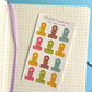 Sheet of colorful mini metal clips on a notebook page with a blue background
