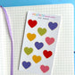 mini hearts as a sticker sheet on top of a notebook background 