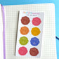 Sheet of colorful wax seal stickers on a notebook with a blue background