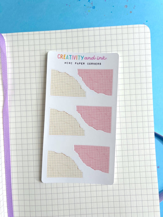 Pack of mini paper corners with grid and solid designs on a notebook page.